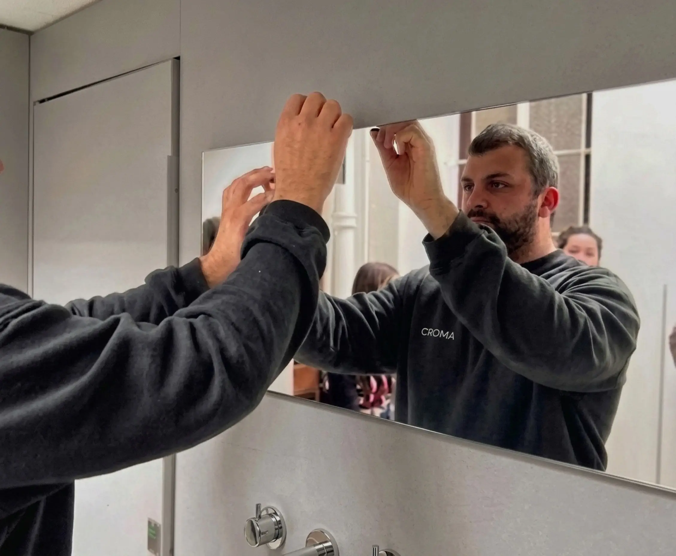 Técnico de Gráfica Croma instalando vinilo en la vidriera de un local comercial en Pilar